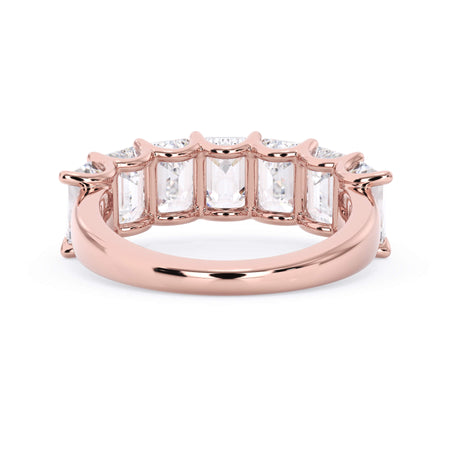 A picture of a seven stone diamond wedding ring with emerald cut diamonds that are U prong set in rose gold on a white background with a view of the underside of the ring.