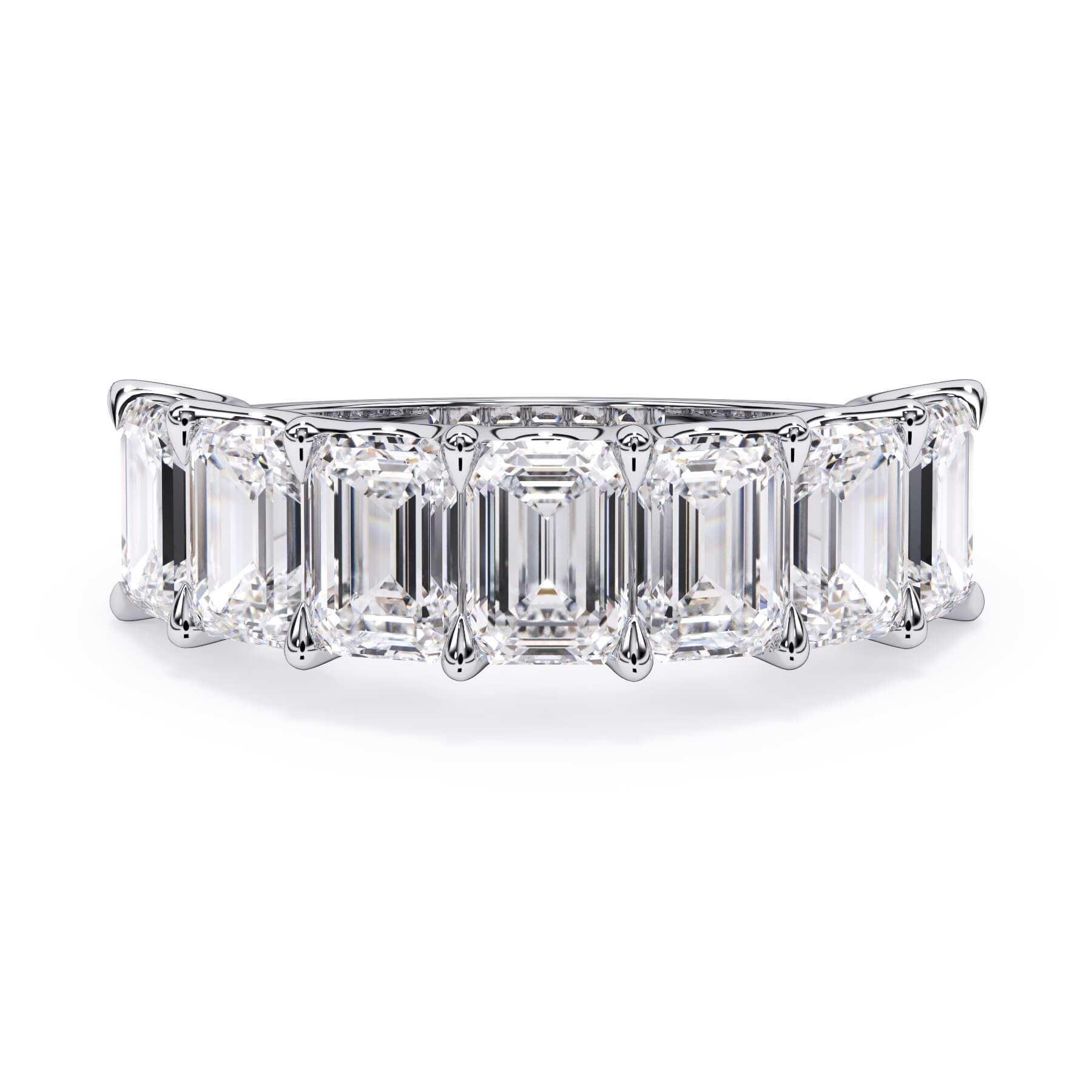 A picture of a seven stone diamond wedding ring with emerald cut diamonds that are U prong set in white gold or platinum on a white background with the ring facing forward, lying down.