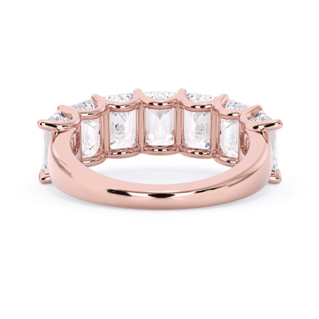 A picture of a seven stone diamond wedding ring with emerald cut diamonds that are U prong set in rose gold on a white background with a view of the underside of the ring.