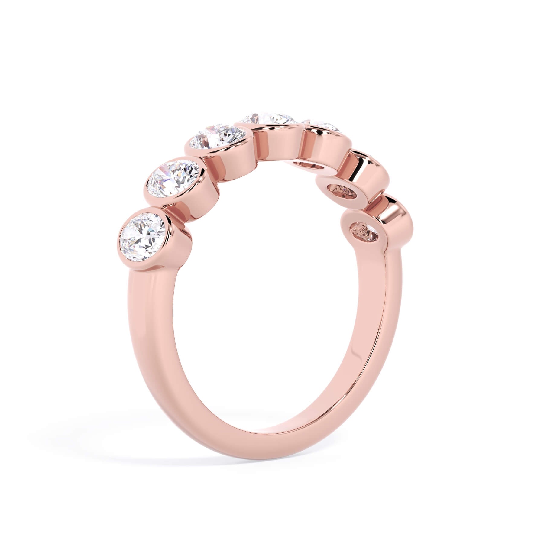 A picture of a seven stone diamond wedding ring with oval shaped diamonds that are bezel set in rose gold on a white background with a slightly angled, through the finger view.