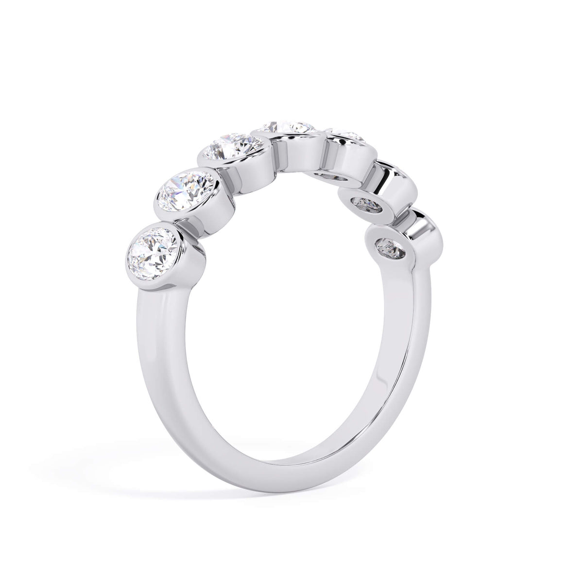 A picture of a seven stone diamond wedding ring with oval shaped diamonds that are bezel set in white gold or platinum on a white background with a slightly angled, through the finger view.