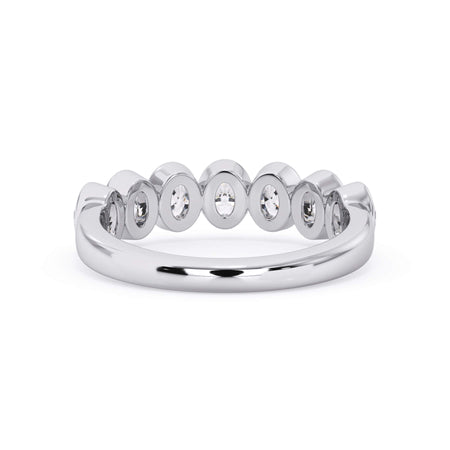 A picture of a seven stone diamond wedding ring with oval shaped diamonds that are bezel set in white gold or platinum on a white background with a view of the underside of the ring.