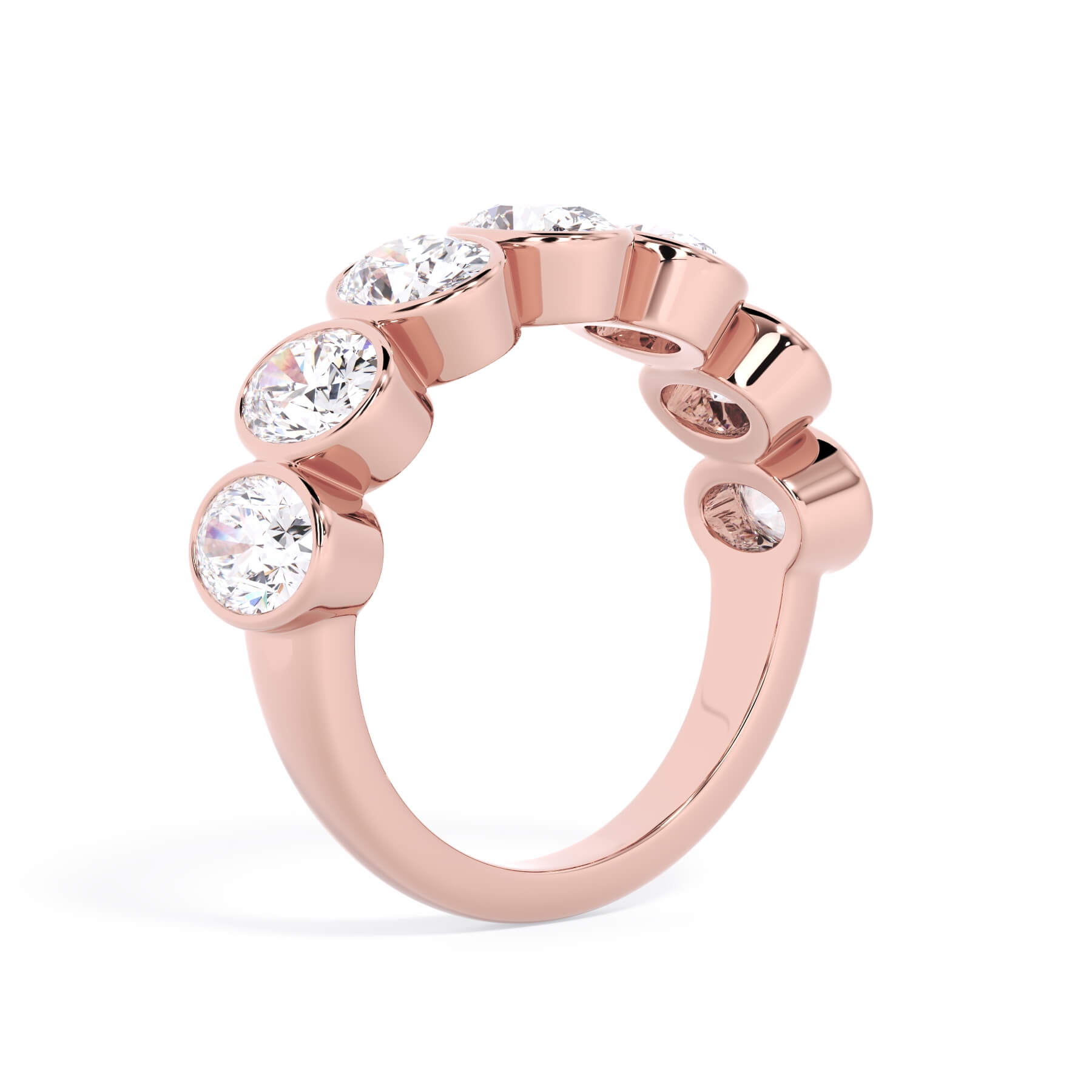 A picture of a seven stone diamond wedding ring with oval shaped diamonds that are bezel set in rose gold on a white background with a slightly angled, through the finger view.