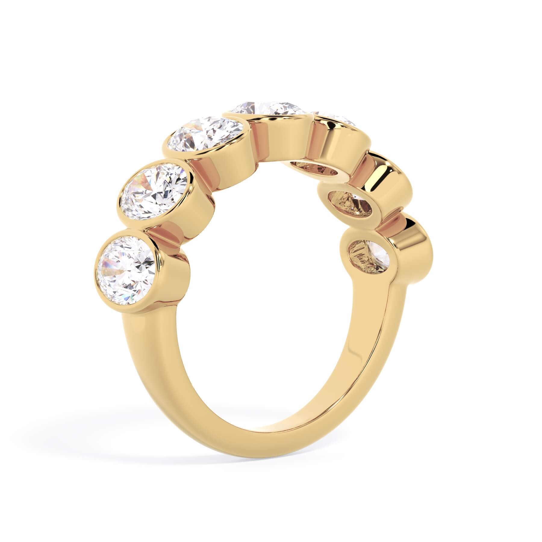 A picture of a seven stone diamond wedding ring with oval shaped diamonds that are bezel set in yellow gold on a white background with a slightly angled, through the finger view.