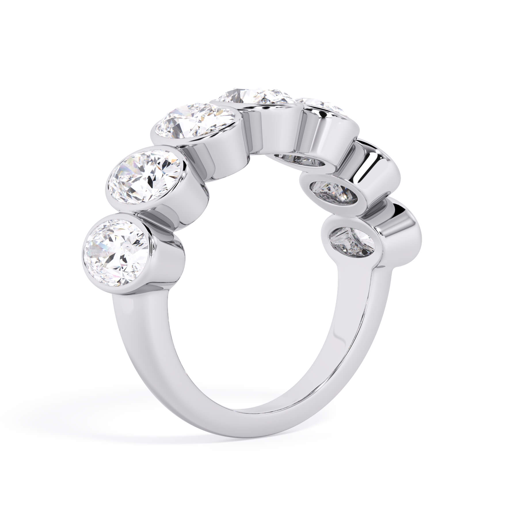 A picture of a seven stone diamond wedding ring with oval shaped diamonds that are bezel set in white gold or platinum on a white background with a slightly angled, through the finger view.