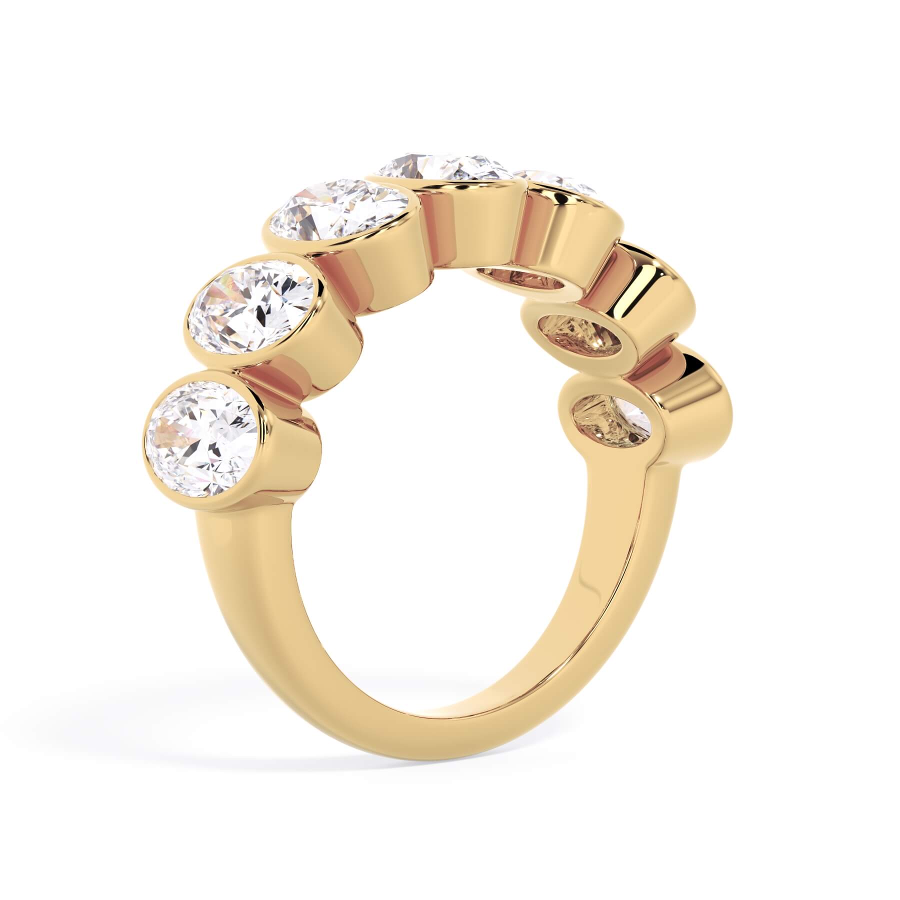 A picture of a seven stone diamond wedding ring with oval shaped diamonds that are bezel set in yellow gold on a white background with a slightly angled, through the finger view.
