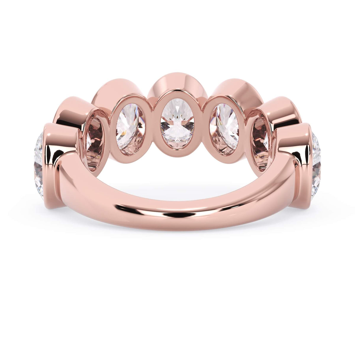 A picture of a seven stone diamond wedding ring with oval shaped diamonds that are bezel set in rose gold on a white background with a view of the underside of the ring.