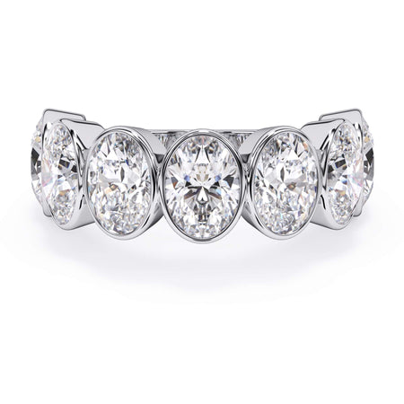 A picture of a seven stone diamond wedding ring with oval shaped diamonds that are bezel set in white gold or platinum on a white background with the ring facing forward, lying down.