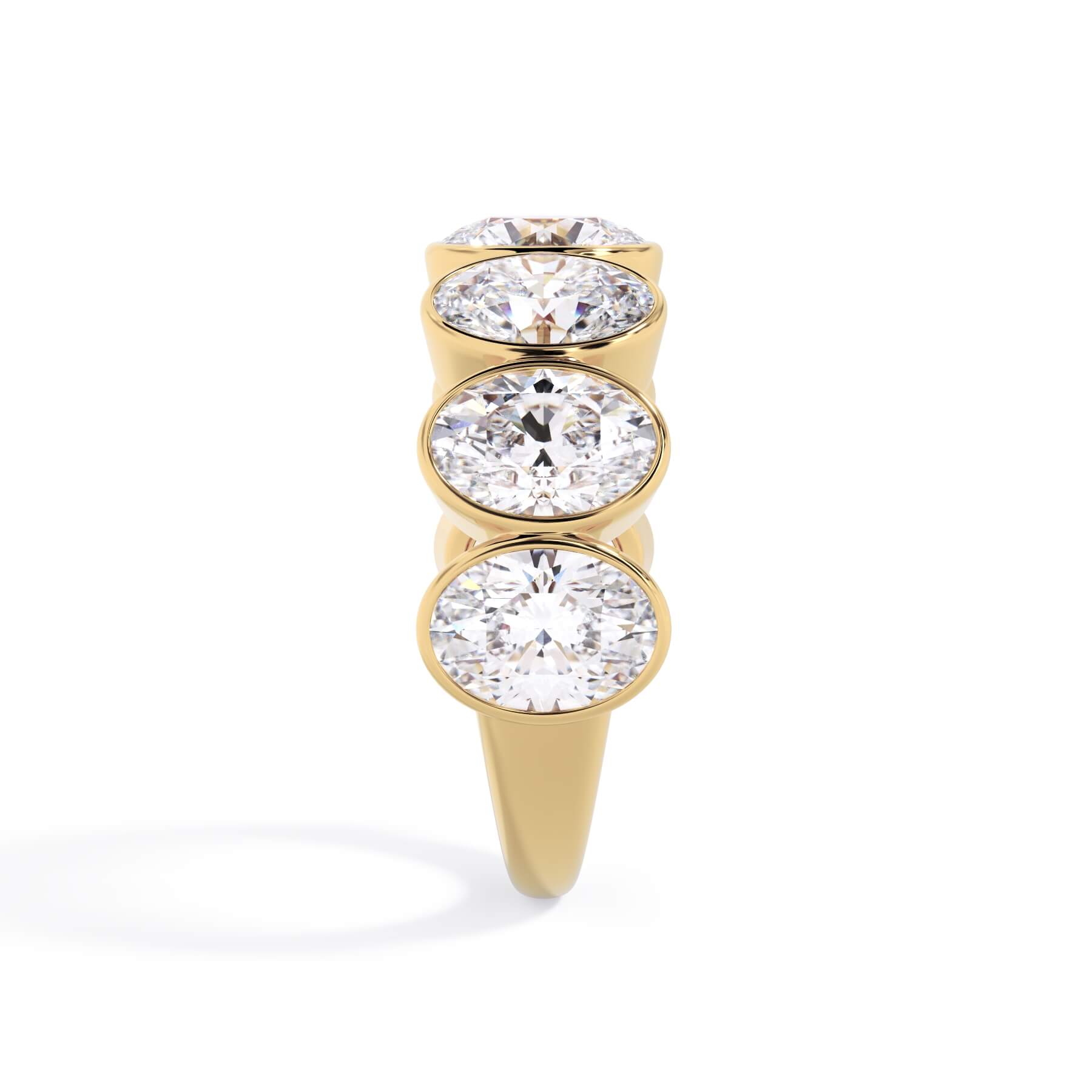 A picture of a seven stone diamond wedding ring with oval shaped diamonds that are bezel set in yellow gold on a white background with a side profile view.