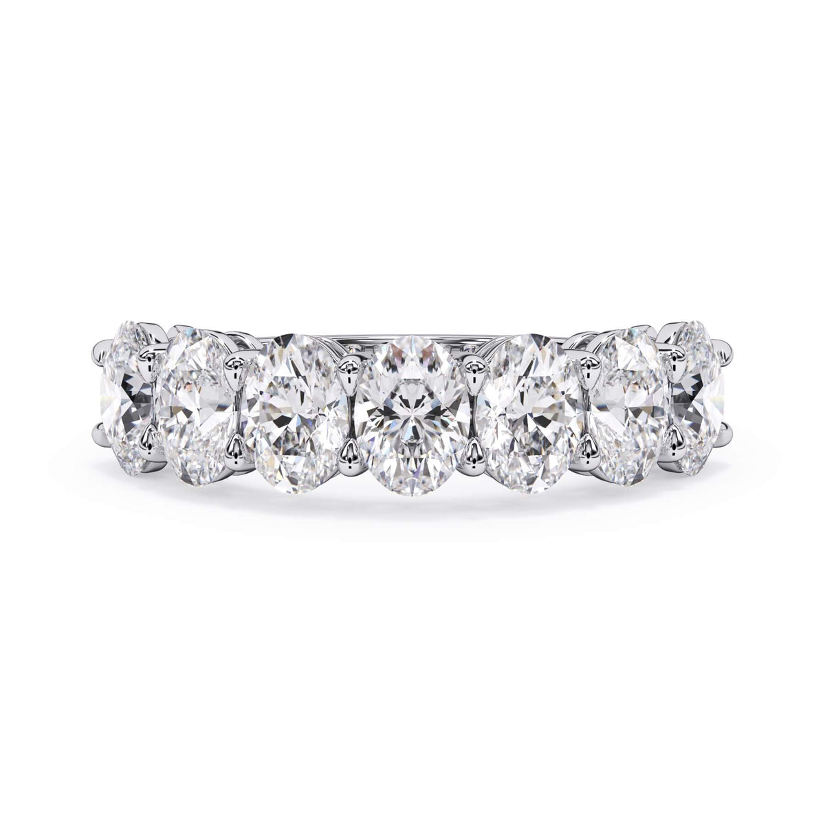 A picture of a seven stone diamond wedding ring with oval shaped diamonds that are shared prong set in white gold or platinum on a white background with the ring facing forward, lying down.