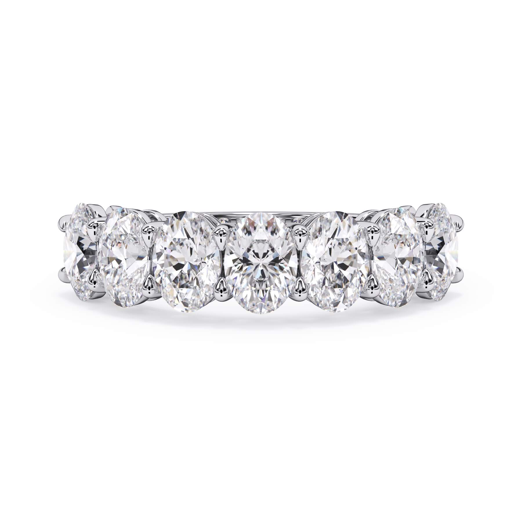 A picture of a seven stone diamond wedding ring with oval shaped diamonds that are shared prong set in white gold or platinum on a white background with the ring facing forward, lying down.