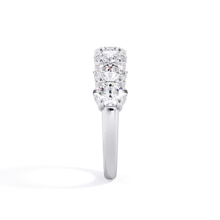 A picture of a seven stone diamond wedding ring with oval shaped diamonds that are shared prong set in white gold or platinum on a white background with a side profile view.