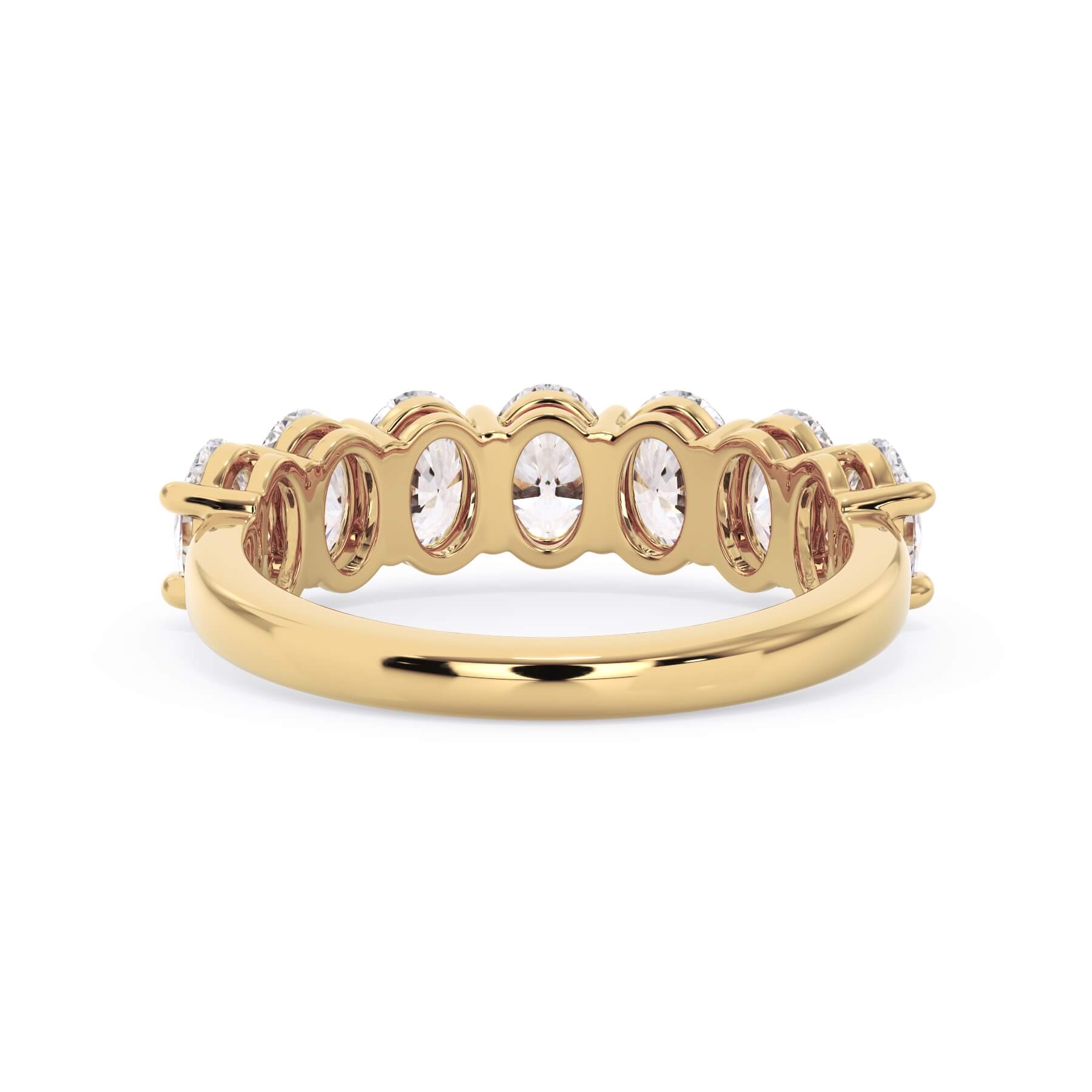 A picture of a seven stone diamond wedding ring with oval shaped diamonds that are shared prong set in yellow gold on a white background with a view of the underside of the ring.