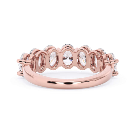 A picture of a seven stone diamond wedding ring with oval shaped diamonds that are shared prong set in rose gold on a white background with a view of the underside of the ring.