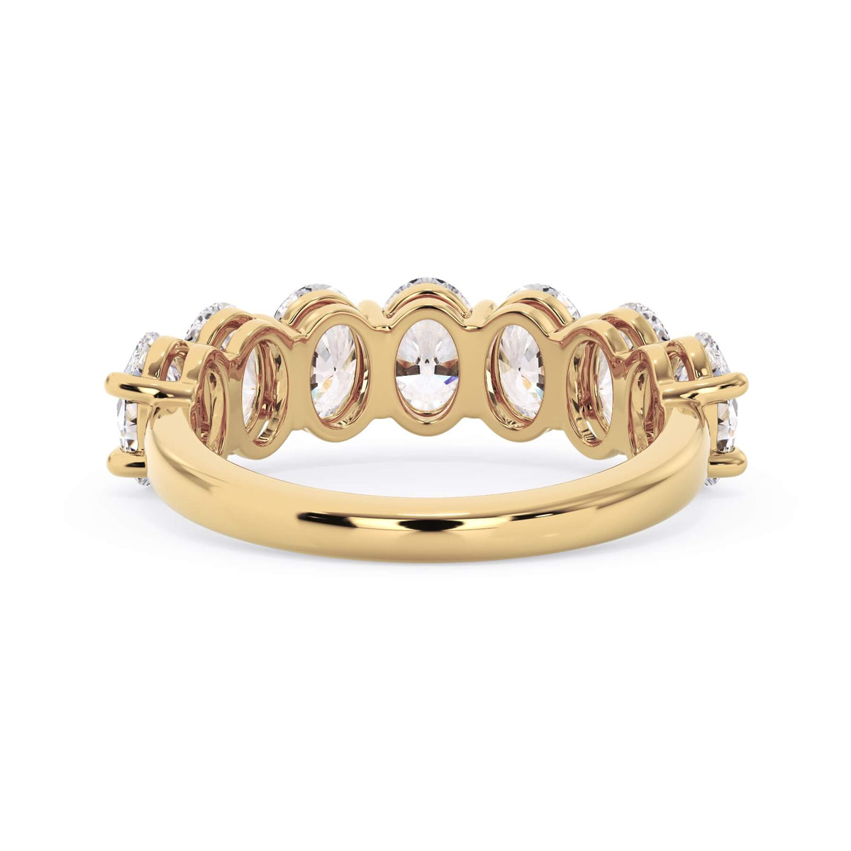 A picture of a seven stone diamond wedding ring with oval shaped diamonds that are shared prong set in yellow gold on a white background with a view of the underside of the ring.