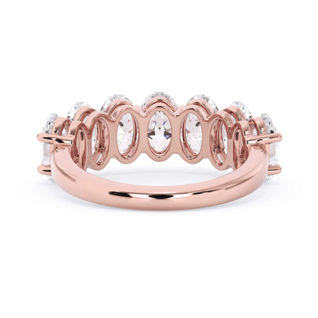A picture of a seven stone diamond wedding ring with oval shaped diamonds that are shared prong set in rose gold on a white background with a view of the underside of the ring.