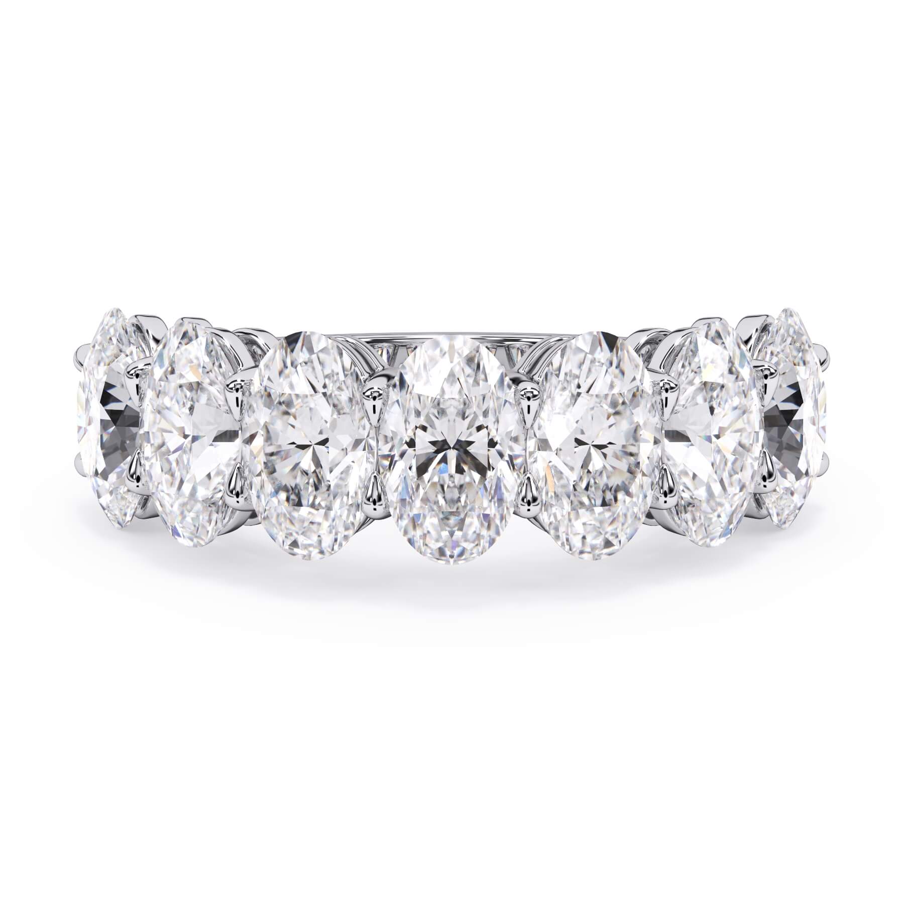 A picture of a seven stone diamond wedding ring with oval shaped diamonds that are shared prong set in white gold or platinum on a white background with the ring facing forward, lying down.
