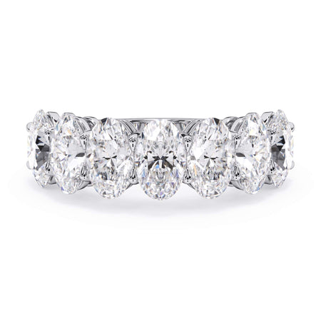 A picture of a seven stone diamond wedding ring with oval shaped diamonds that are shared prong set in white gold or platinum on a white background with the ring facing forward, lying down.