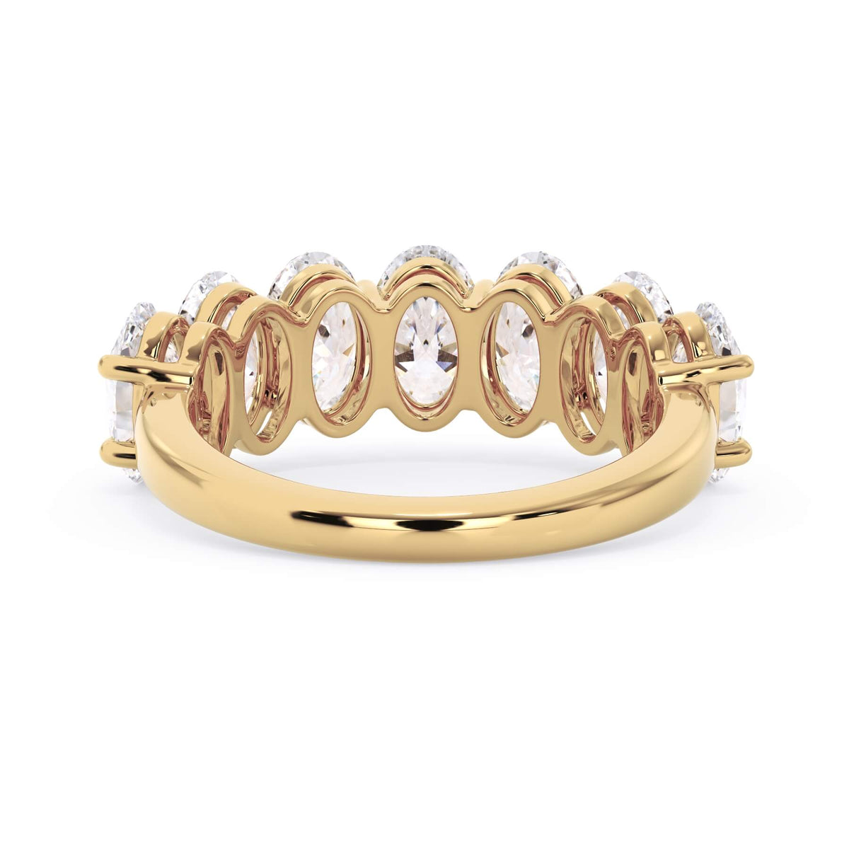 A picture of a seven stone diamond wedding ring with oval shaped diamonds that are shared prong set in yellow gold on a white background with a view of the underside of the ring.
