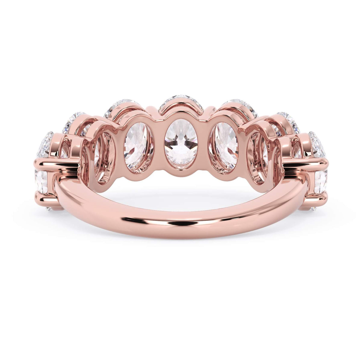A picture of a seven stone diamond wedding ring with oval shaped diamonds that are shared prong set in rose gold on a white background with a view of the underside of the ring.
