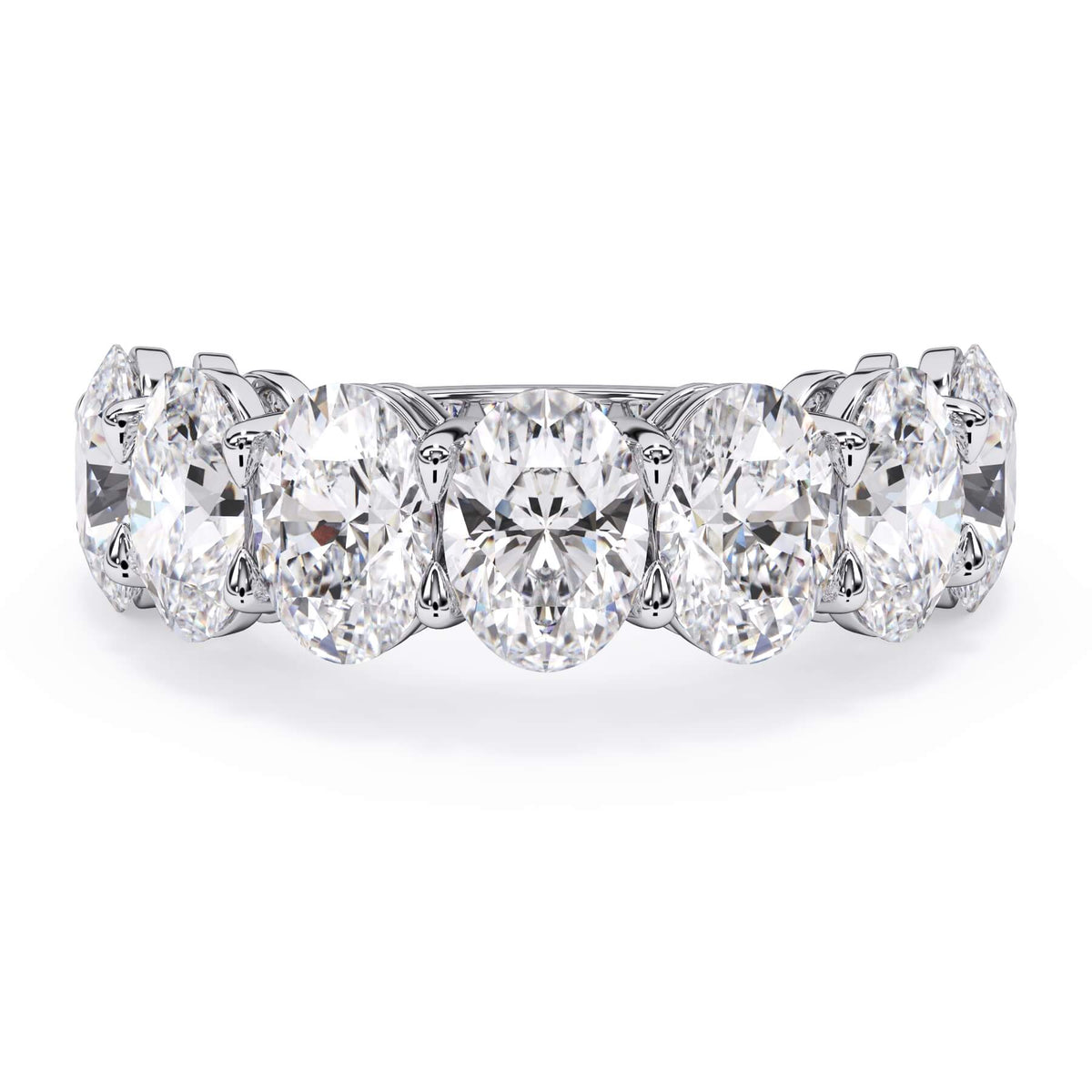 A picture of a seven stone diamond wedding ring with oval shaped diamonds that are shared prong set in white gold or platinum on a white background with the ring facing forward, lying down.