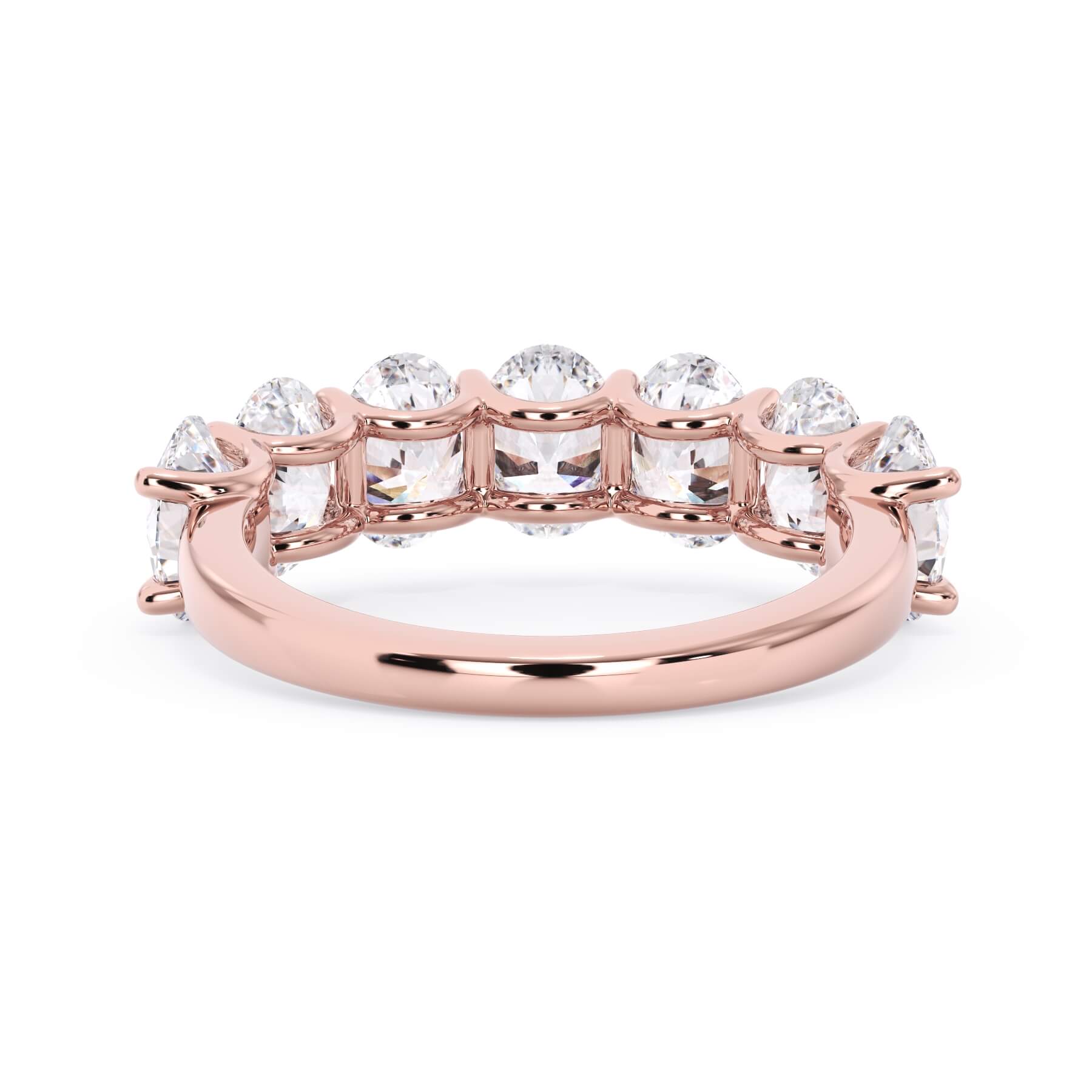 A picture of a seven stone diamond wedding ring with oval shaped diamonds that are U prong set in rose gold on a white background with a view of the underside of the ring.