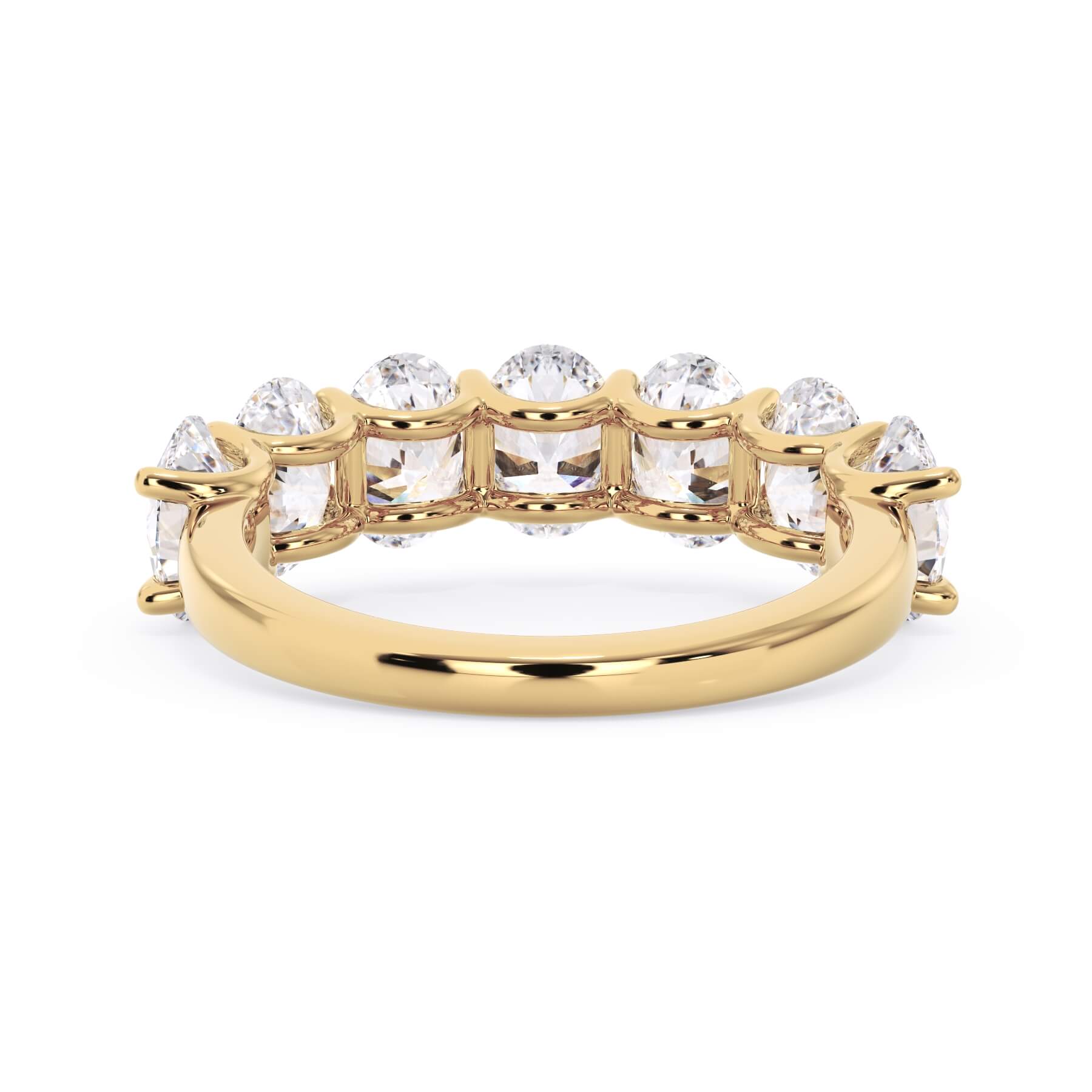 A picture of a seven stone diamond wedding ring with oval shaped diamonds that are U prong set in yellow gold on a white background with a view of the underside of the ring.