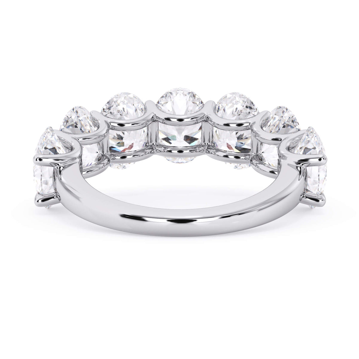 A picture of a seven stone diamond wedding ring with oval shaped diamonds that are U prong set in white gold or platinum on a white background with a view of the underside of the ring.