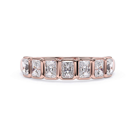 A picture of a seven stone diamond wedding ring with radiant cut diamonds that are bezel set in rose gold on a white background with the ring facing forward, lying down.