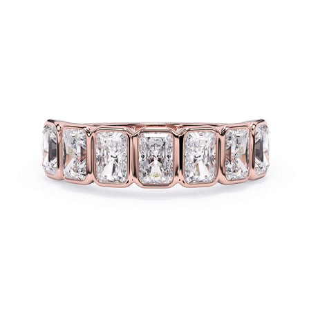 A picture of a seven stone diamond wedding ring with radiant cut diamonds that are bezel set in rose gold on a white background with the ring facing forward, lying down.