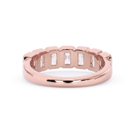 A picture of a seven stone diamond wedding ring with radiant cut diamonds that are bezel set in rose gold on a white background with a view of the underside of the ring.