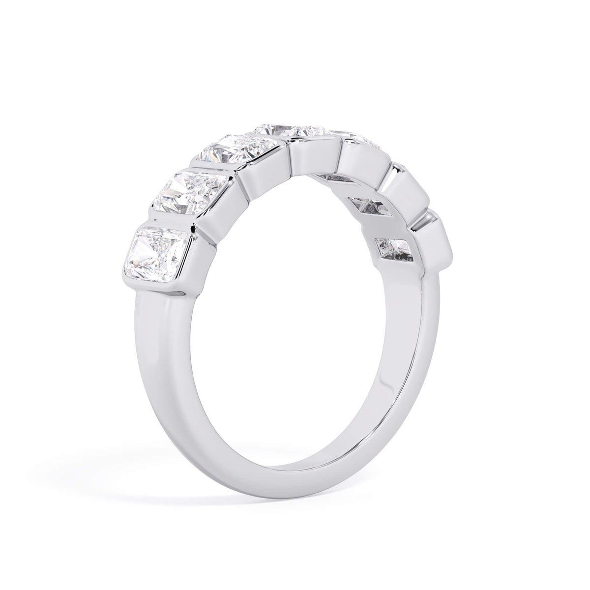 A picture of a seven stone diamond wedding ring with radiant cut diamonds that are bezel set in white gold or platinum on a white background with a slightly angled, through the finger view.
