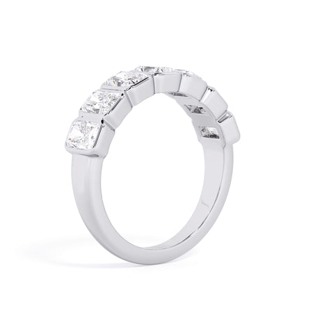 A picture of a seven stone diamond wedding ring with radiant cut diamonds that are bezel set in white gold or platinum on a white background with a slightly angled, through the finger view.