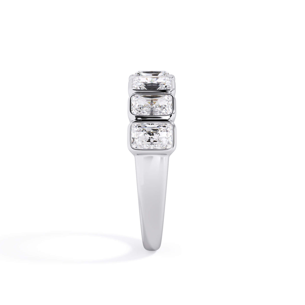 A picture of a seven stone diamond wedding ring with radiant cut diamonds that are bezel set in white gold or platinum on a white background with a side profile view.