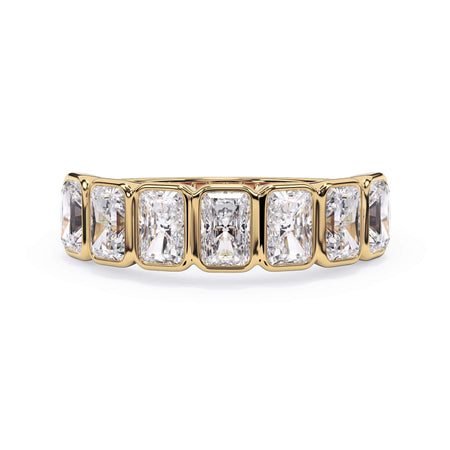 A picture of a seven stone diamond wedding ring with radiant cut diamonds that are bezel set in yellow gold on a white background with the ring facing forward, lying down.