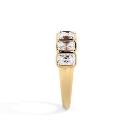 A picture of a seven stone diamond wedding ring with radiant cut diamonds that are bezel set in yellow gold on a white background with a side profile view.