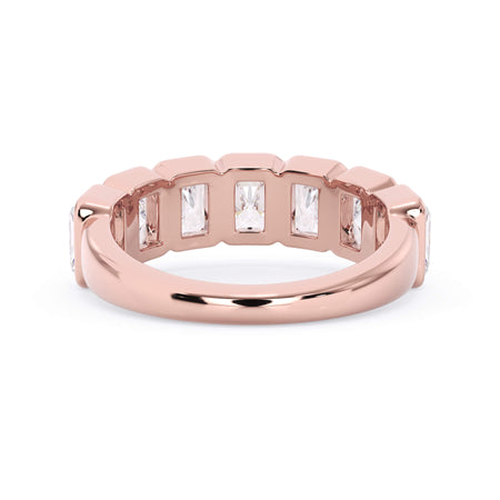 A picture of a seven stone diamond wedding ring with radiant cut diamonds that are bezel set in rose gold on a white background with a view of the underside of the ring.