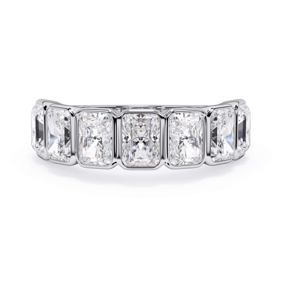 A picture of a seven stone diamond wedding ring with radiant cut diamonds that are bezel set in white gold or platinum on a white background with the ring facing forward, lying down.