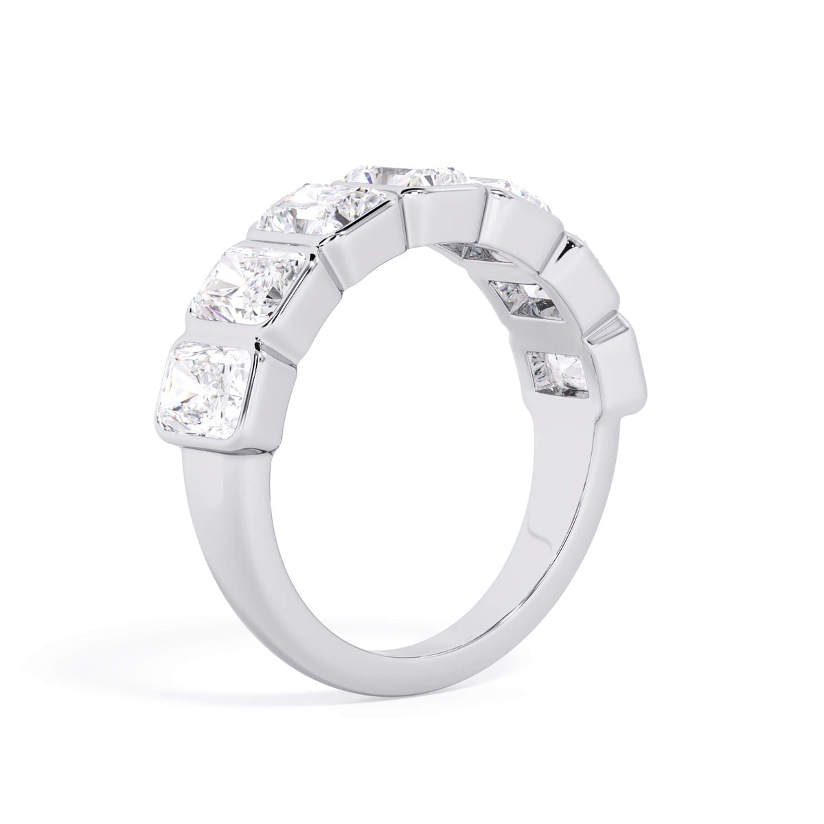 A picture of a seven stone diamond wedding ring with radiant cut diamonds that are bezel set in white gold or platinum on a white background with a slightly angled, through the finger view.