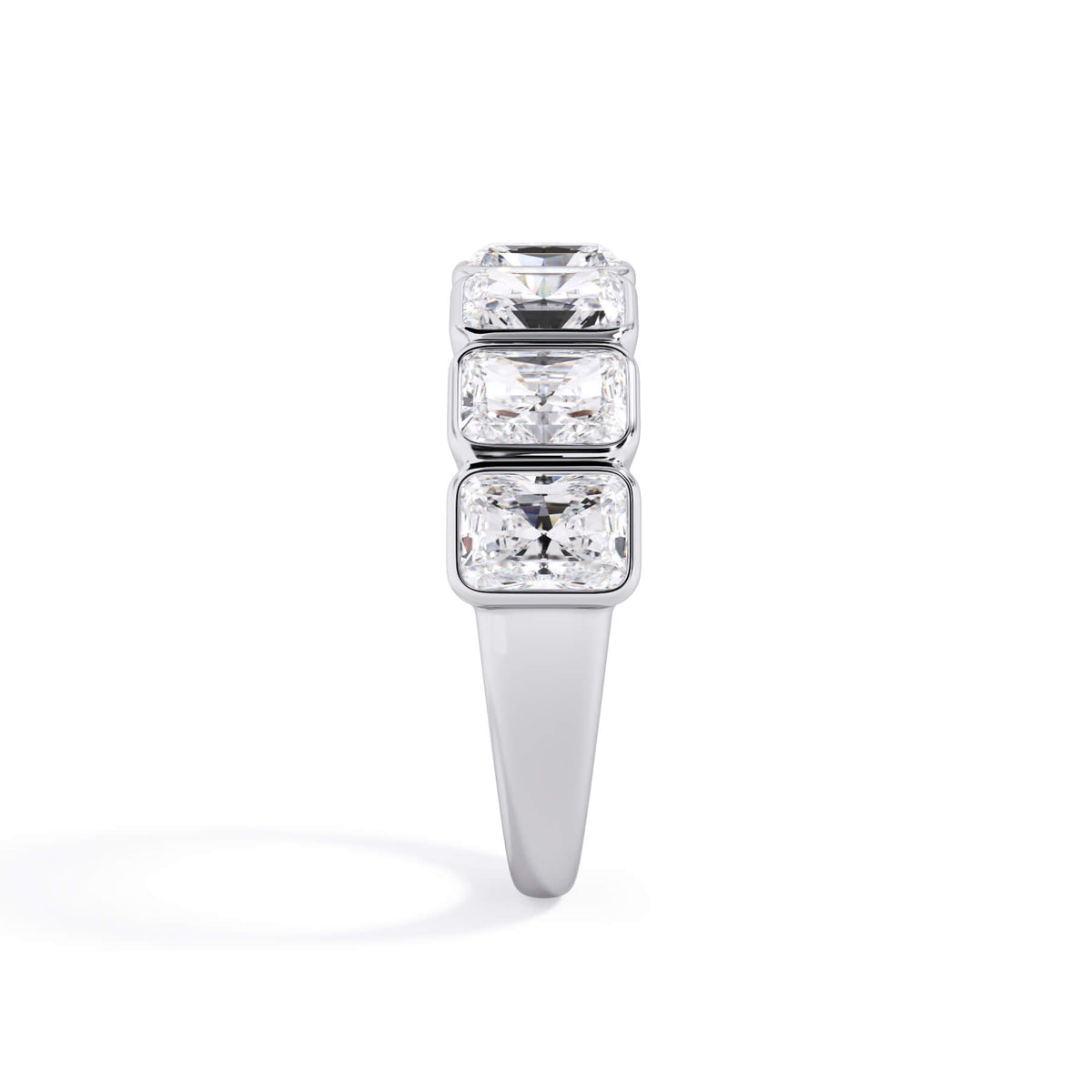 A picture of a seven stone diamond wedding ring with radiant cut diamonds that are bezel set in white gold or platinum on a white background with a side profile view.