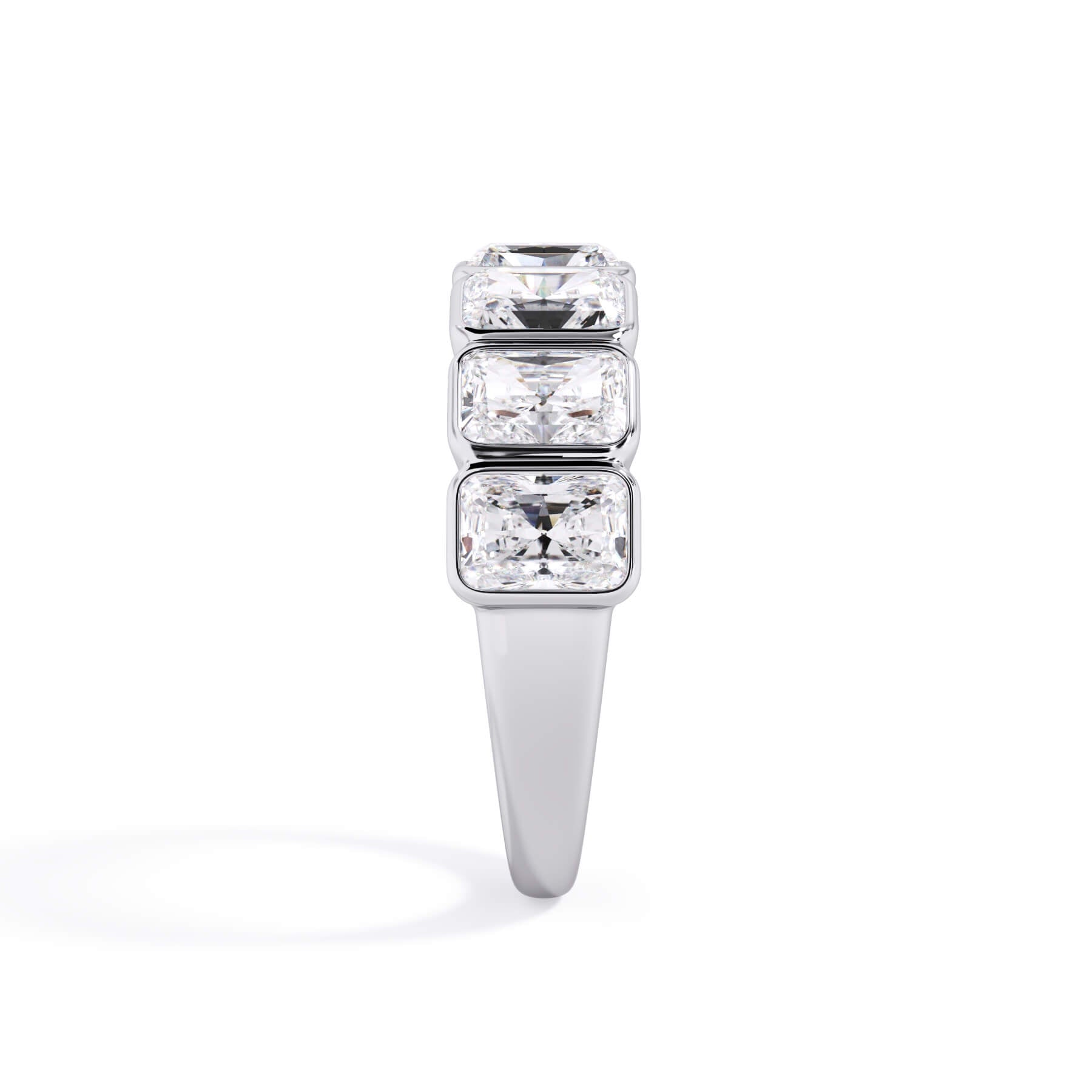 A picture of a seven stone diamond wedding ring with radiant cut diamonds that are bezel set in white gold or platinum on a white background with a side profile view.