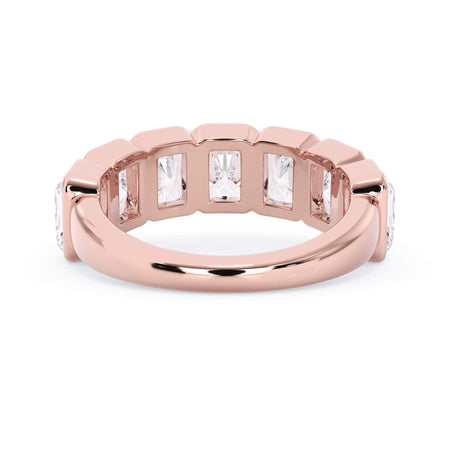 A picture of a seven stone diamond wedding ring with radiant cut diamonds that are bezel set in rose gold on a white background with a view of the underside of the ring.