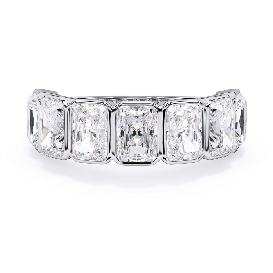 A picture of a seven stone diamond wedding ring with radiant cut diamonds that are bezel set in white gold or platinum on a white background with the ring facing forward, lying down.