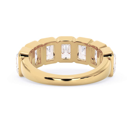 A picture of a seven stone diamond wedding ring with radiant cut diamonds that are bezel set in yellow gold on a white background with a view of the underside of the ring.
