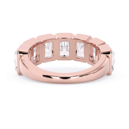 A picture of a seven stone diamond wedding ring with radiant cut diamonds that are bezel set in rose gold on a white background with a view of the underside of the ring.