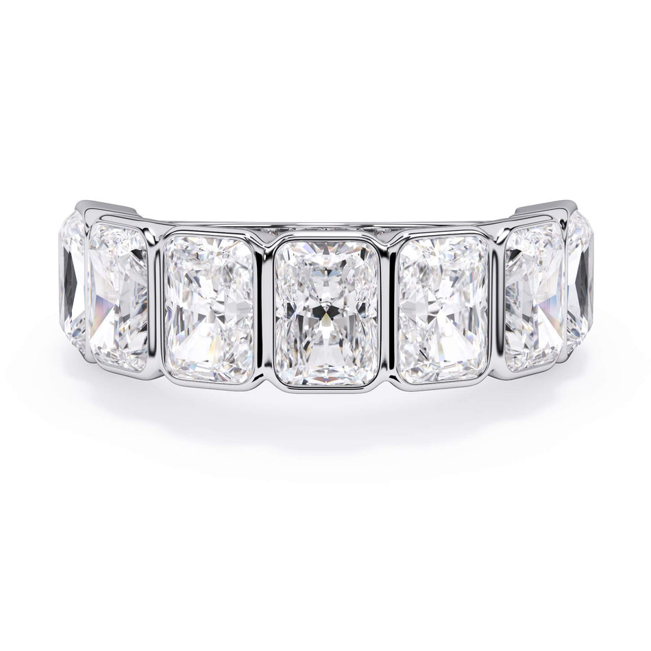 A picture of a seven stone diamond wedding ring with radiant cut diamonds that are bezel set in white gold or platinum on a white background with the ring facing forward, lying down.
