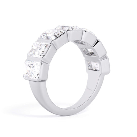A picture of a seven stone diamond wedding ring with radiant cut diamonds that are bezel set in white gold or platinum on a white background with a slightly angled, through the finger view.