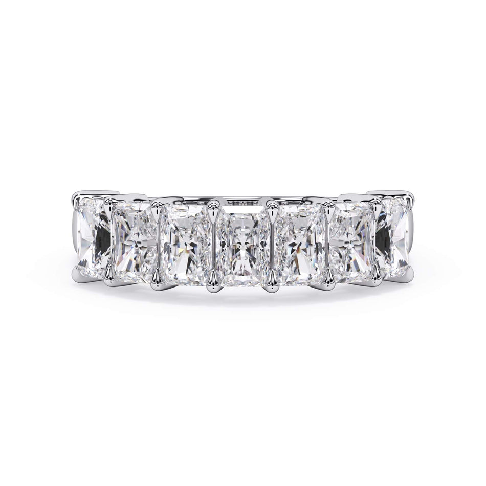 A picture of a seven stone diamond wedding ring with radiant cut diamonds that are shared prong set in white gold or platinum on a white background with the ring facing forward, lying down.