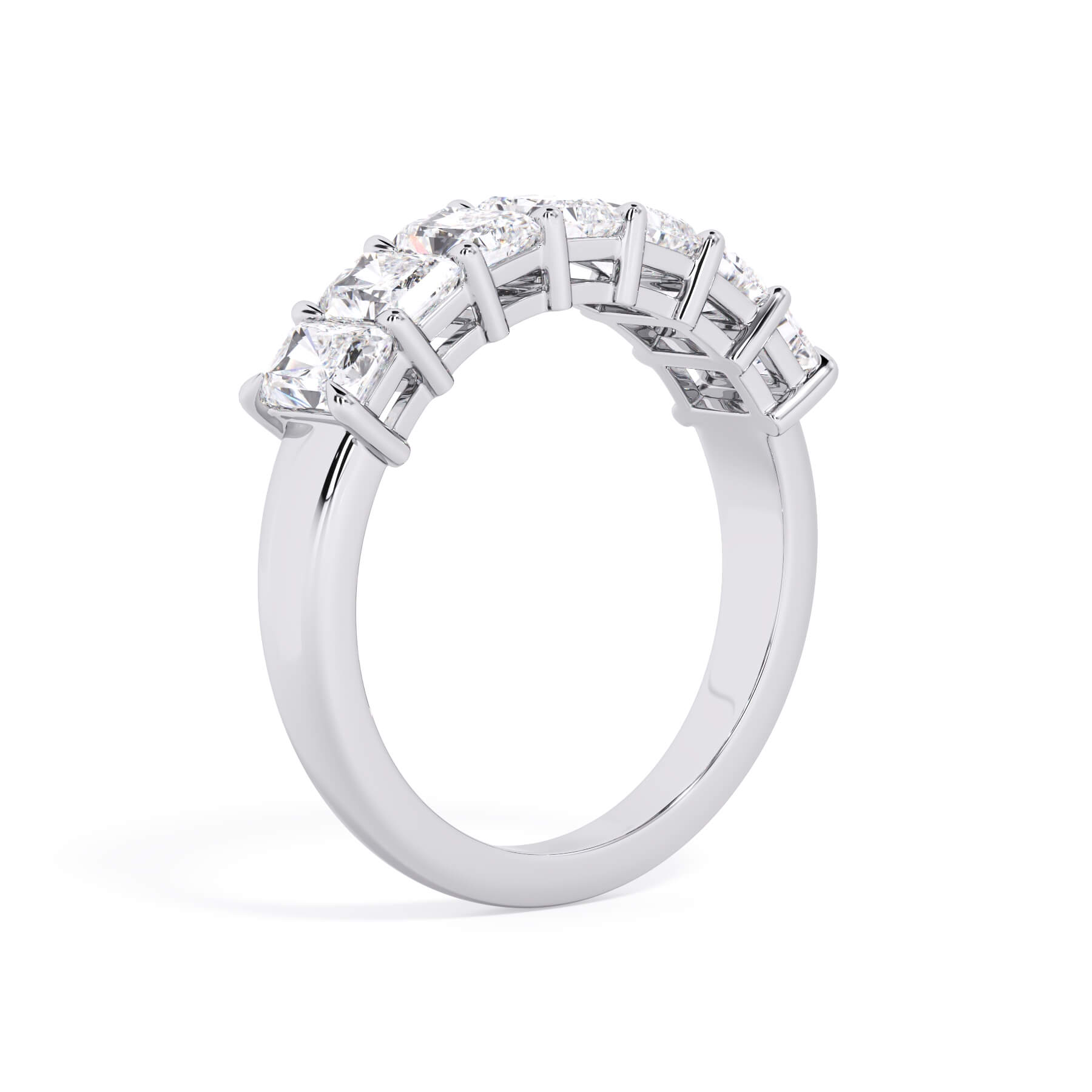 A picture of a seven stone diamond wedding ring with radiant cut diamonds that are shared prong set in white gold or platinum on a white background with a slightly angled, through the finger view.