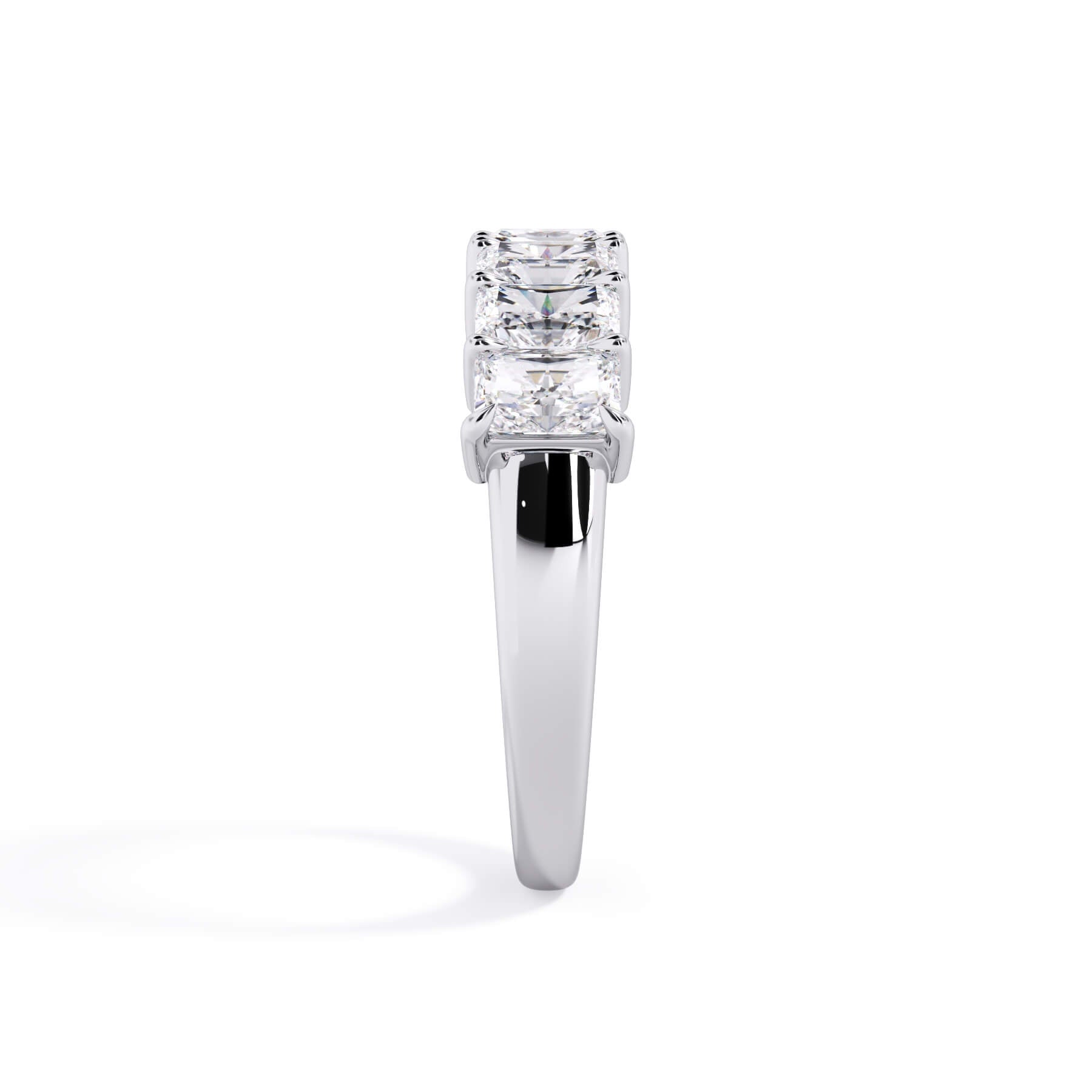 A picture of a seven stone diamond wedding ring with radiant cut diamonds that are shared prong set in white gold or platinum on a white background with a side profile view.
